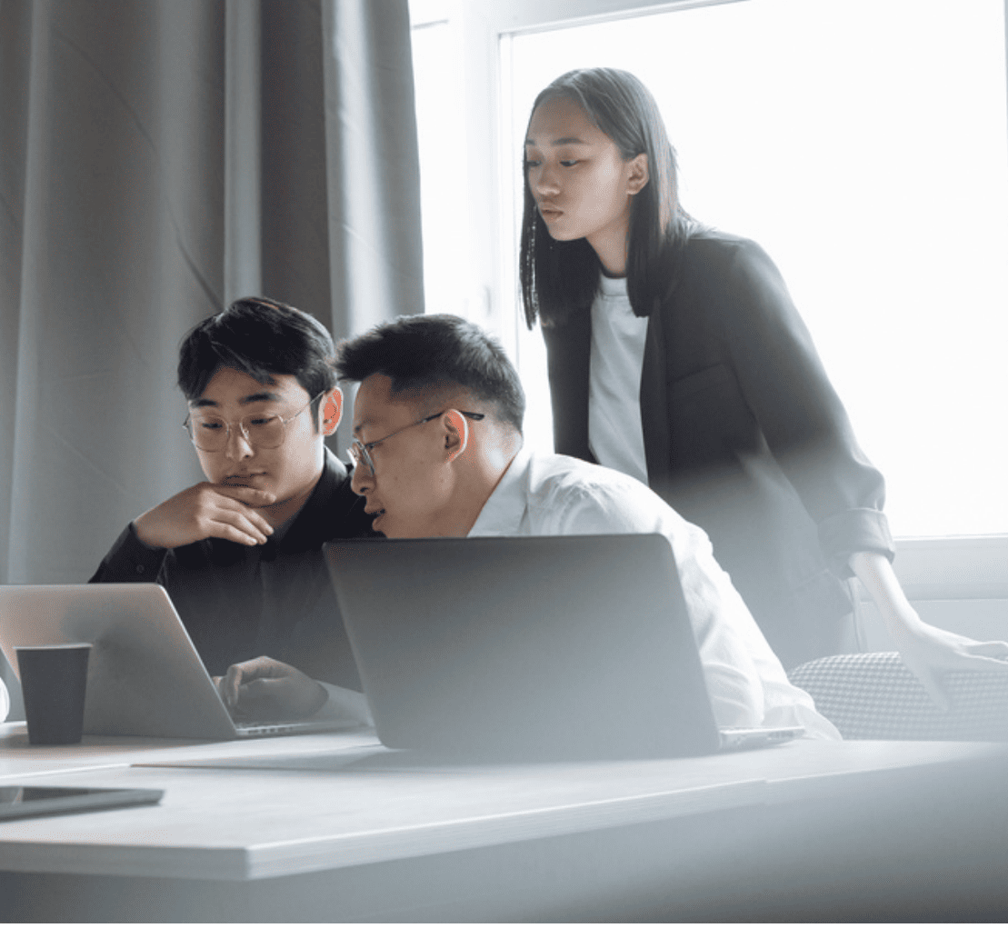 Software Chain of Custody: 3 workers looking over laptop in collaborative environment